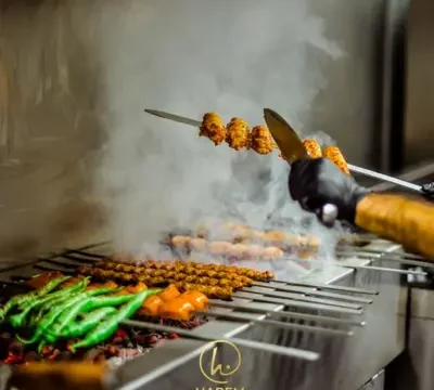 Harem Restaurant adana kebab, groene pepers en tomtaat op de houtskoolgrill